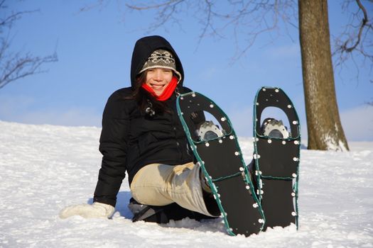 Young woman taking a hiking break with Snow shoes / Rackets in Quebec, Canada