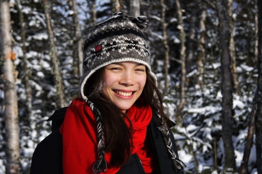Young smiling woman in winter forest landscape, Quebec, Canada