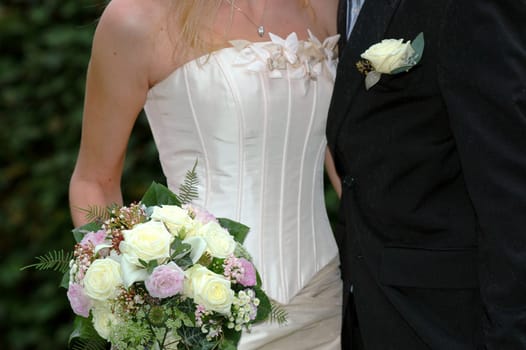 Wedding couple standing together holding flowers.