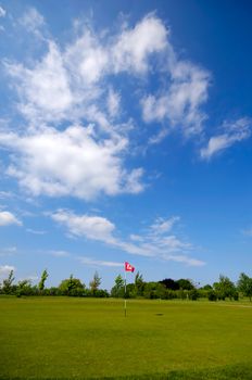 Golf cours with blue and cloudy sky