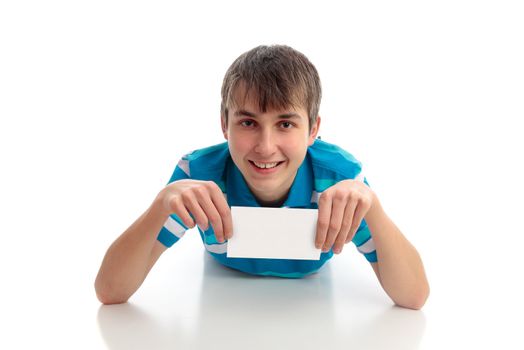 A boy lying down holding a small sign, award, card, book, or other object.  White background.