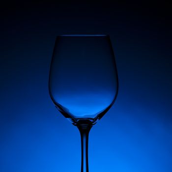 Empty wine glass with blue background.