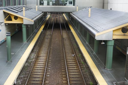 a view from the top of a subway station with the railways in the middle