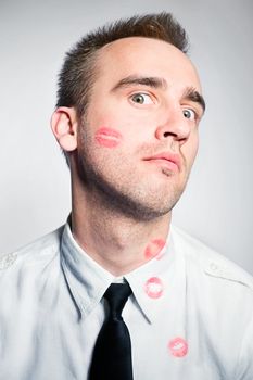 young handsome man with lips imprints on cheek and shirt