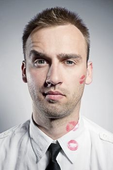 young handsome man with kiss imprints on cheek and shirt