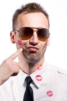 young man pointing on cheek with lips imprint