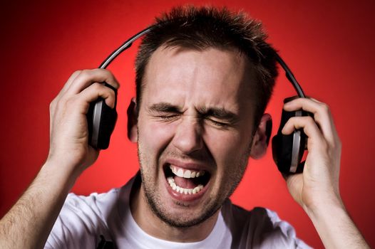 young man with wry face on his face because of loud music