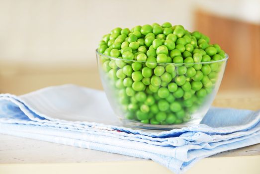 young fresh green spring peas in glass bowl