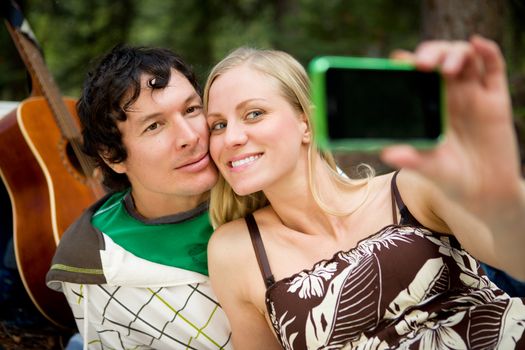 A happy couple outdoors taking a self portrait with a camera phone