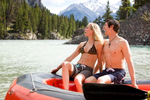 A man and woman rafting on a river