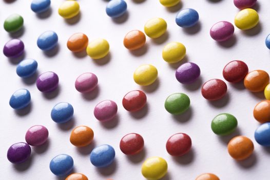 colorful pills scattered on white background