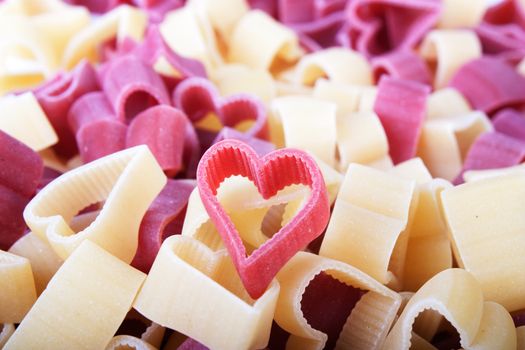 Red and yellow pasta hearts filling frame. 
