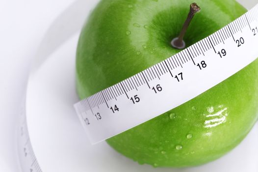 fresh green apple with measure tape in close up
