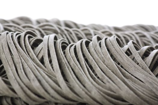 Ribbons of tagliatelle pasta on white background..