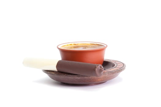 Coffee and chocolate tube on a wooden saucer