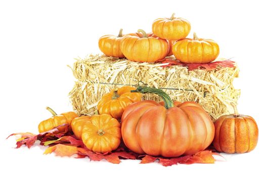 Macro of pumpkins around a bale of hay isolated on a white background.
