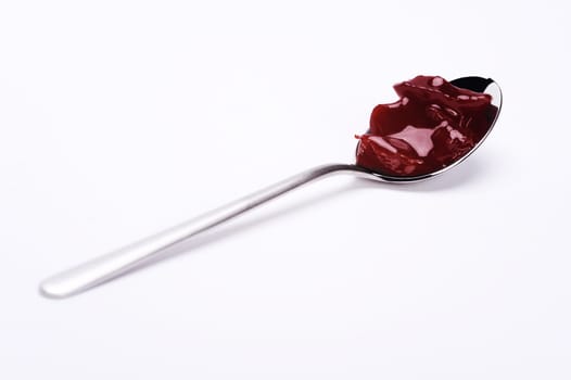 spoon with cherry jam over white background