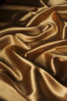textile golden satin background draped in waves