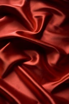 textile red satin background draped in waves