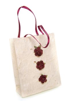 a handmade white bag with three little red roses on a white background