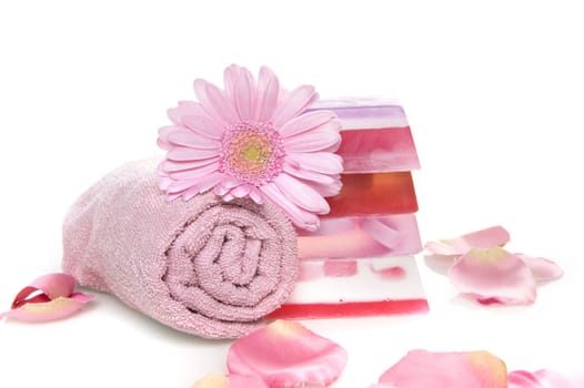 a towel with a pile of soap and  flowerleaves