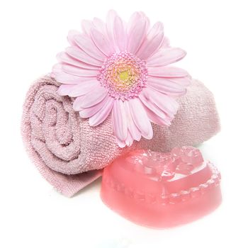 a towel, soap and a flower