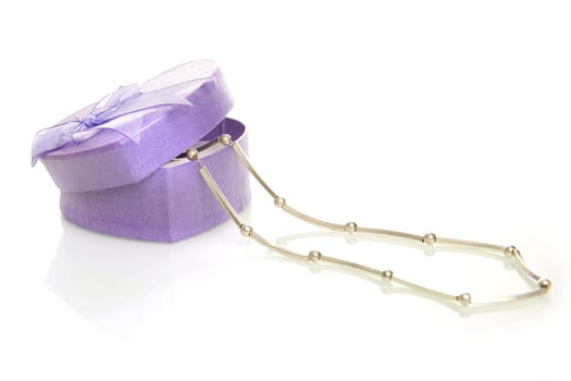 a purple heart box with jewellery on a white background