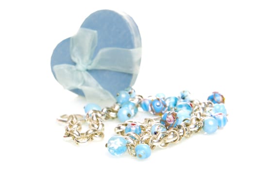 a blue heart box with jewellery on a white background