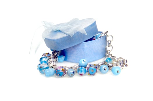 a blue heart box with jewellery on a white background