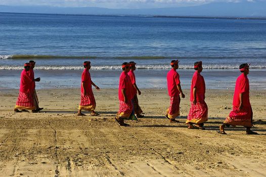 Balinese men walking on the beach after participating in a Hindu religious ceremony. 93% of the people of Bali are Hindus, even though the vast majority of the population of Indonesia belong to the Islamic faith. Jimbaran beach, Bali, Indonesia. January 22, 2008.