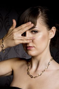 portrait of woman wearing golden necklace over wallpaper background