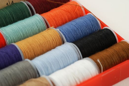 colorful spools of multi colored threads for sewing and knitting