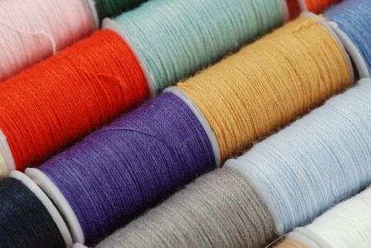 colorful spools of multi colored threads for sewing and knitting