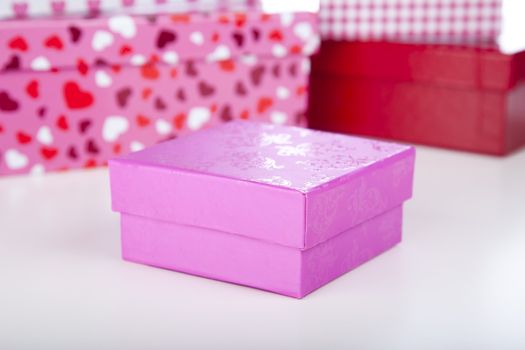 Pink gift box for birthday, Christmas or valentines gift.  Shallow depth of field with gift boxes in background.
