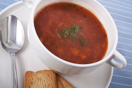 Bowl of minestrone soup with spoon and crackers
