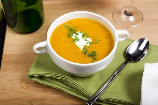 Pumpkin soup on green napkin with spoon.  