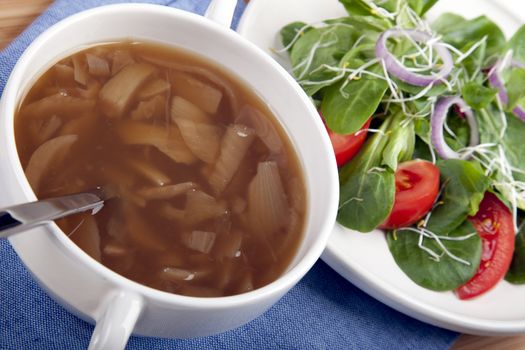 Onion soup with spoon and side salad.