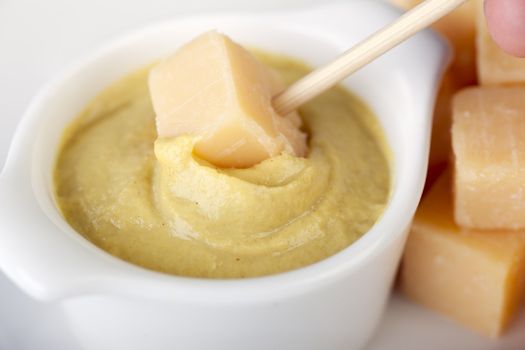 Dutch treat of cheese being dipped into spicy mustard