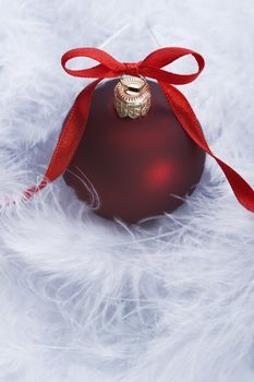 christmas ball with decorative red ribbon on feather