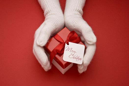 christmas gift with decorative red ribbon on red background