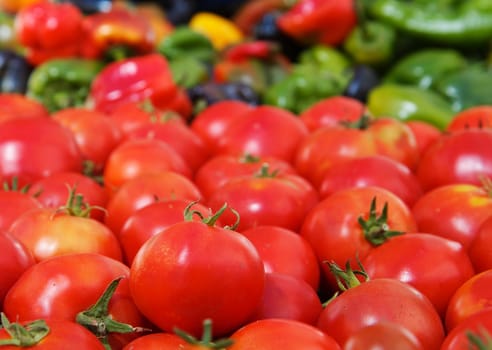 Pile of red tomatoes and various colored peppers