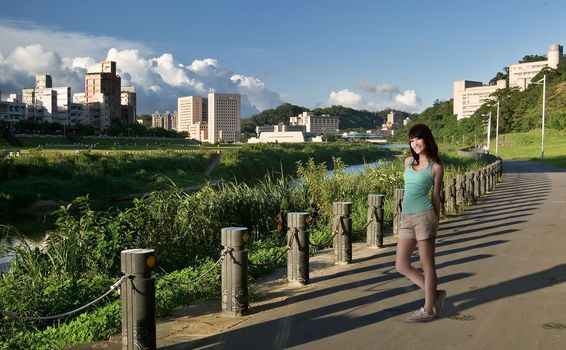 Happy smiling woman in outdoor in sunset city park near river.