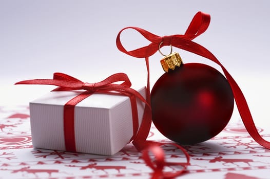 christmas gift and ball with decorative red ribbon