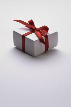 gift with decorative red ribbon on white background