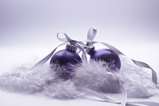 christmas balls with decorative silver ribbon on feather