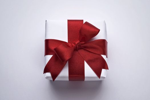 christmas gift with decorative red ribbon on white background