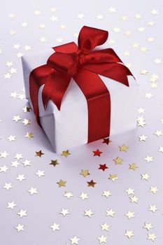 gift with decorative red ribbon on stars background