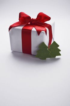 christmas gift with decorative red ribbon and trees