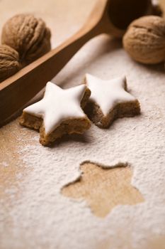 nuts and star shaped glazed cookies on wooden board