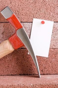 White piece of paper for a message next to a hammer. Add your text to the paper.